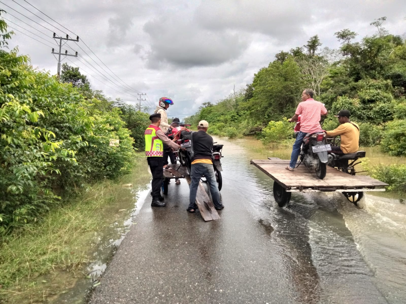 Jalan Tertutup Banjir, Polisi Bantu Warga Seberangkan Motor