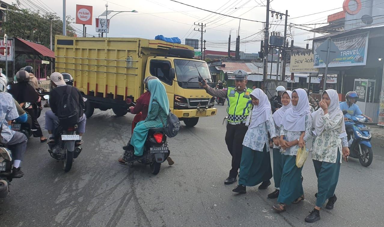 Strong Point Pagi, Personel Satlantas Polres Aceh Barat Bantu Anak Sekolah Nyebrang Jalan