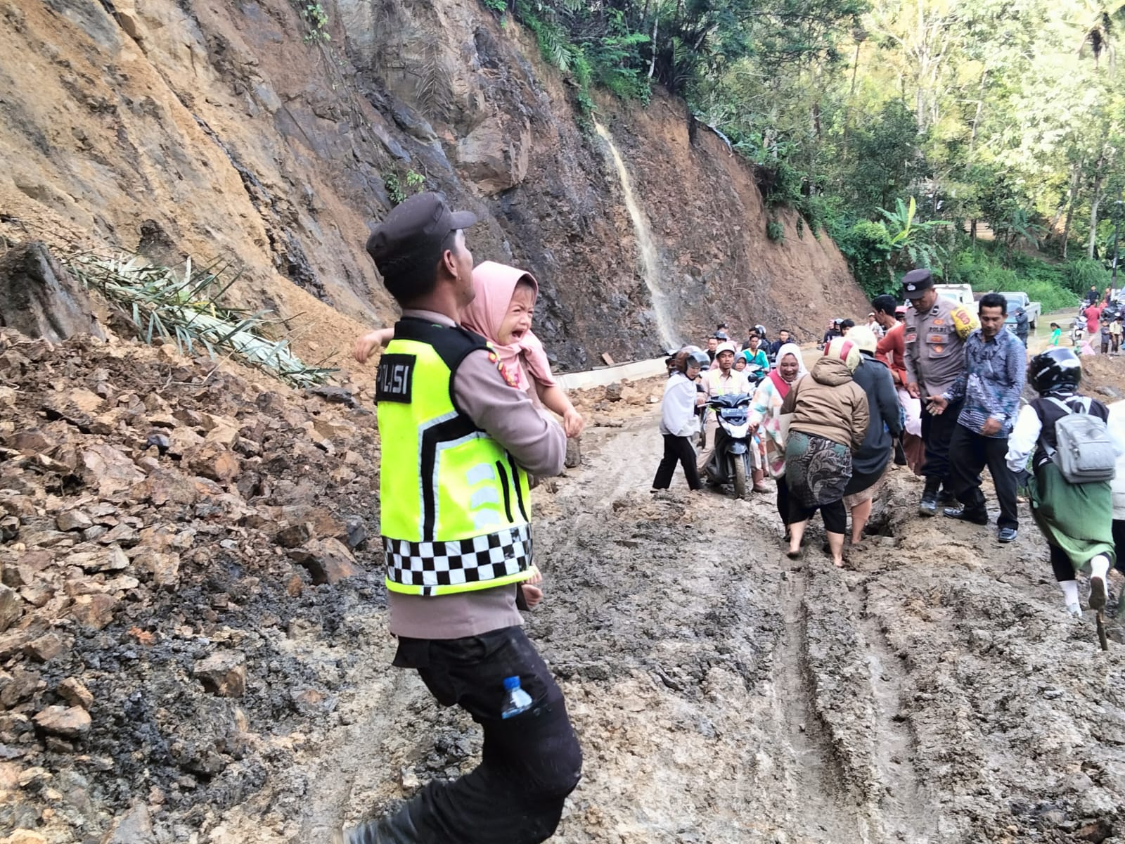 Respon Cepat Polsek Silih Nara Datangi Lokasi Tanah Longsor Dan Bantu Evakuasi Warga Menyebrang